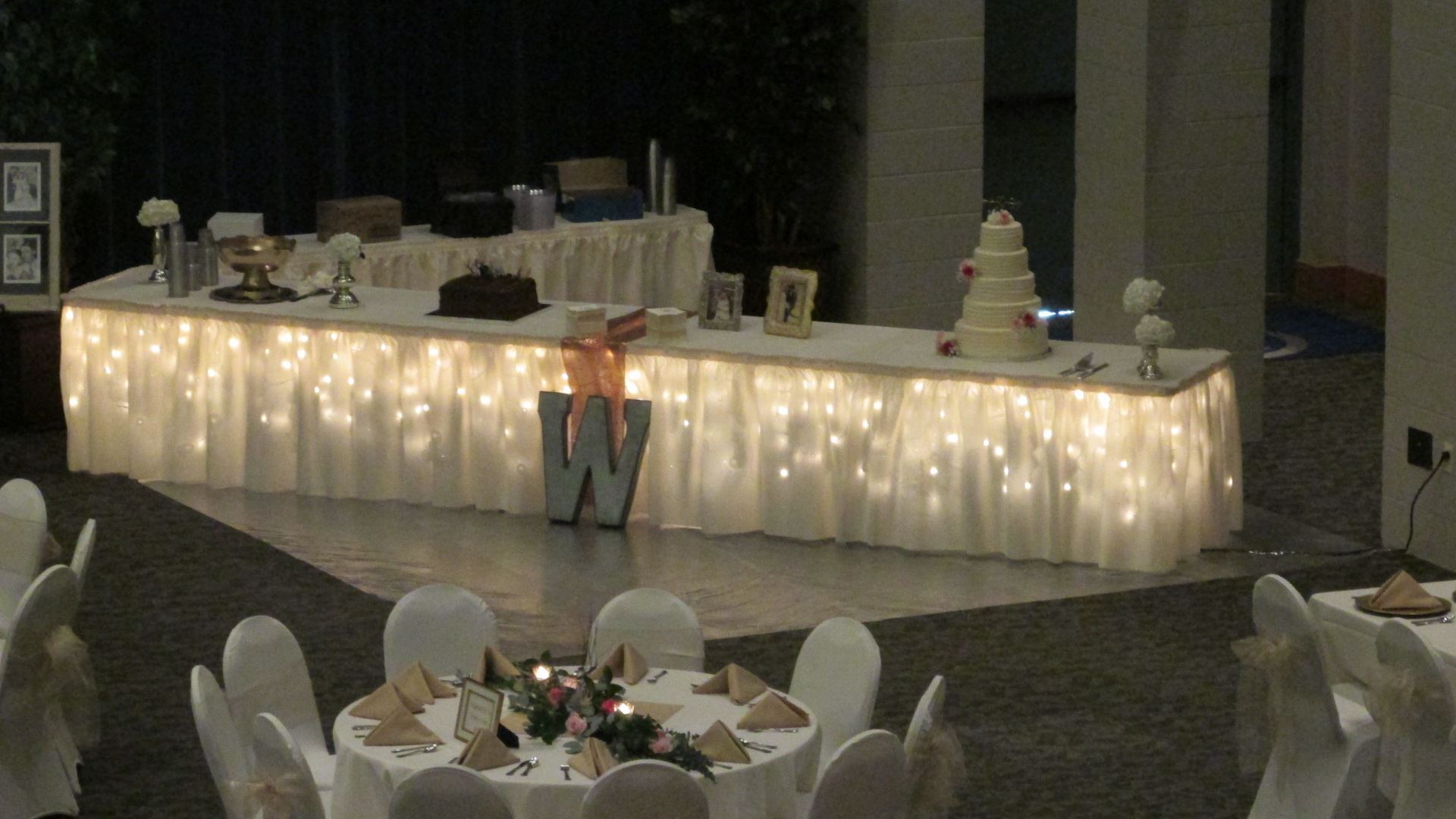 Lighted wedding cake station with two tables