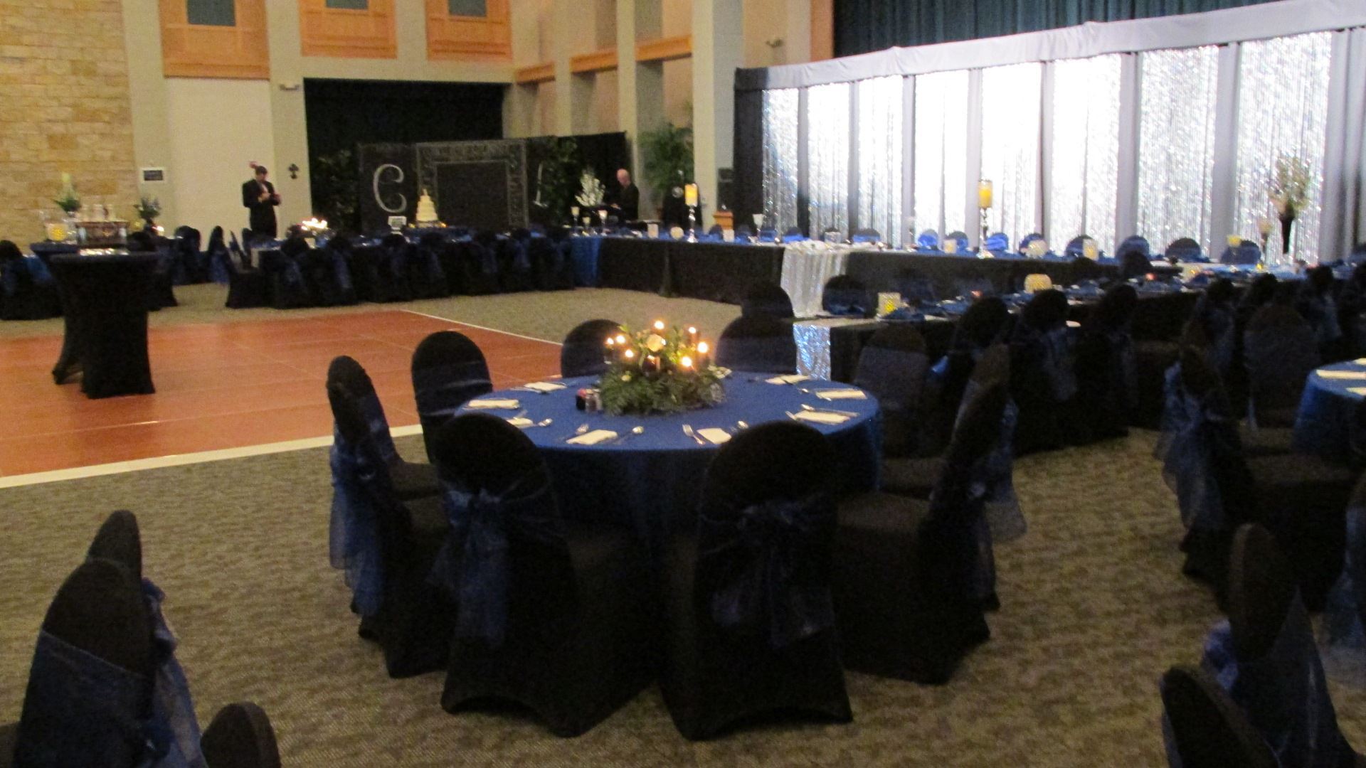 Royal wedding reception floor view of black and blue tables with dance floor in the middle